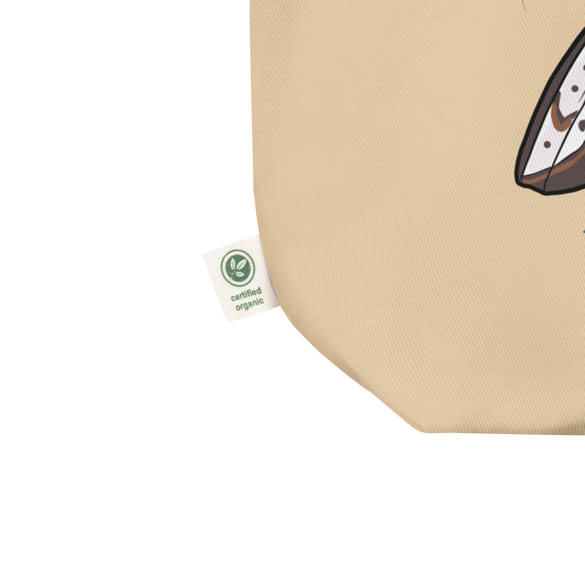 Close-up of beige organic cotton fabric with green certified organic tag and partial graphic print