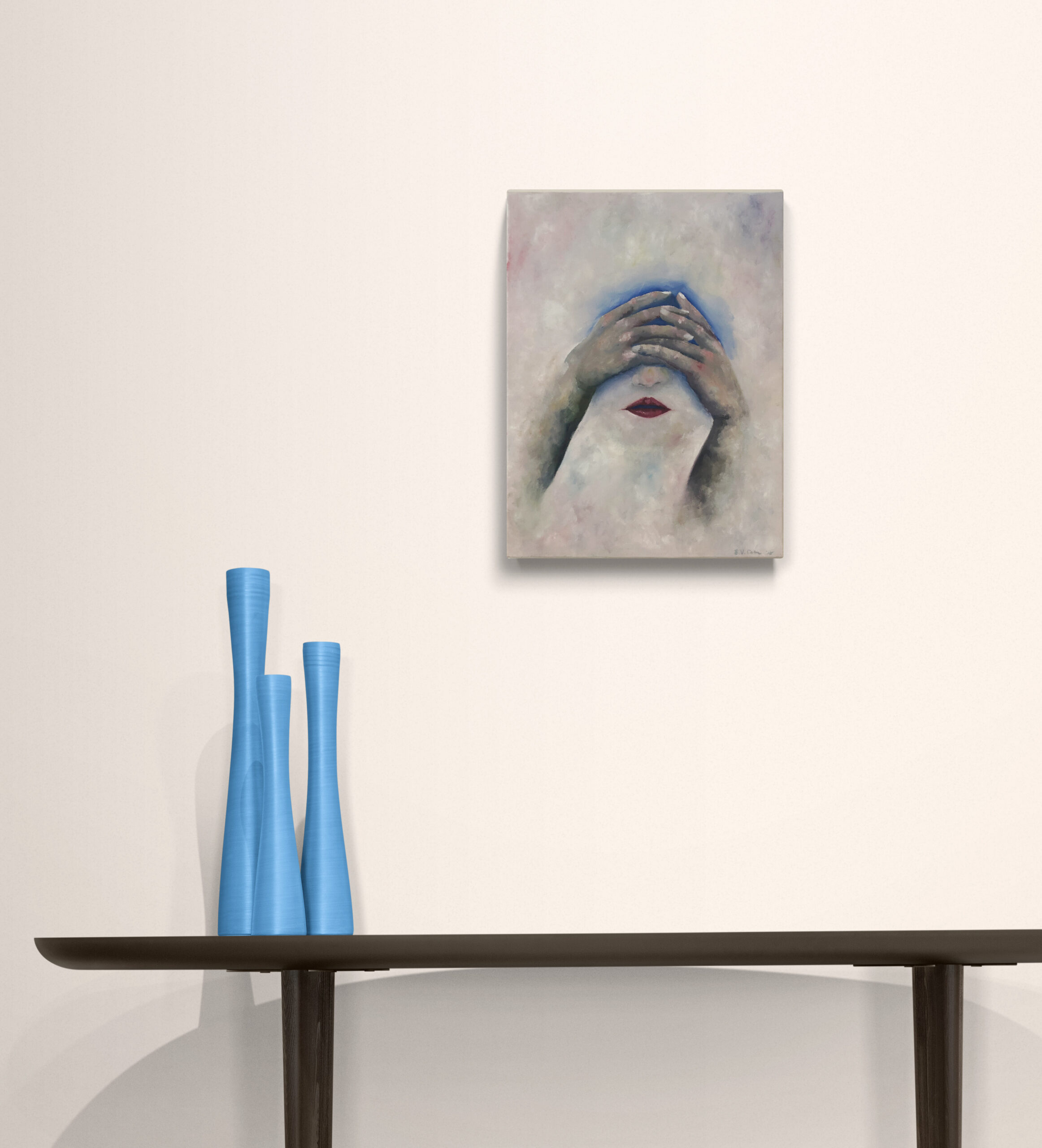 Abstract portrait showing hands covering eyes with red lips, displayed above a dark console table with tall blue vases.