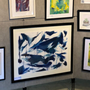 Large framed abstract blue watercolor painting displayed on gallery wall