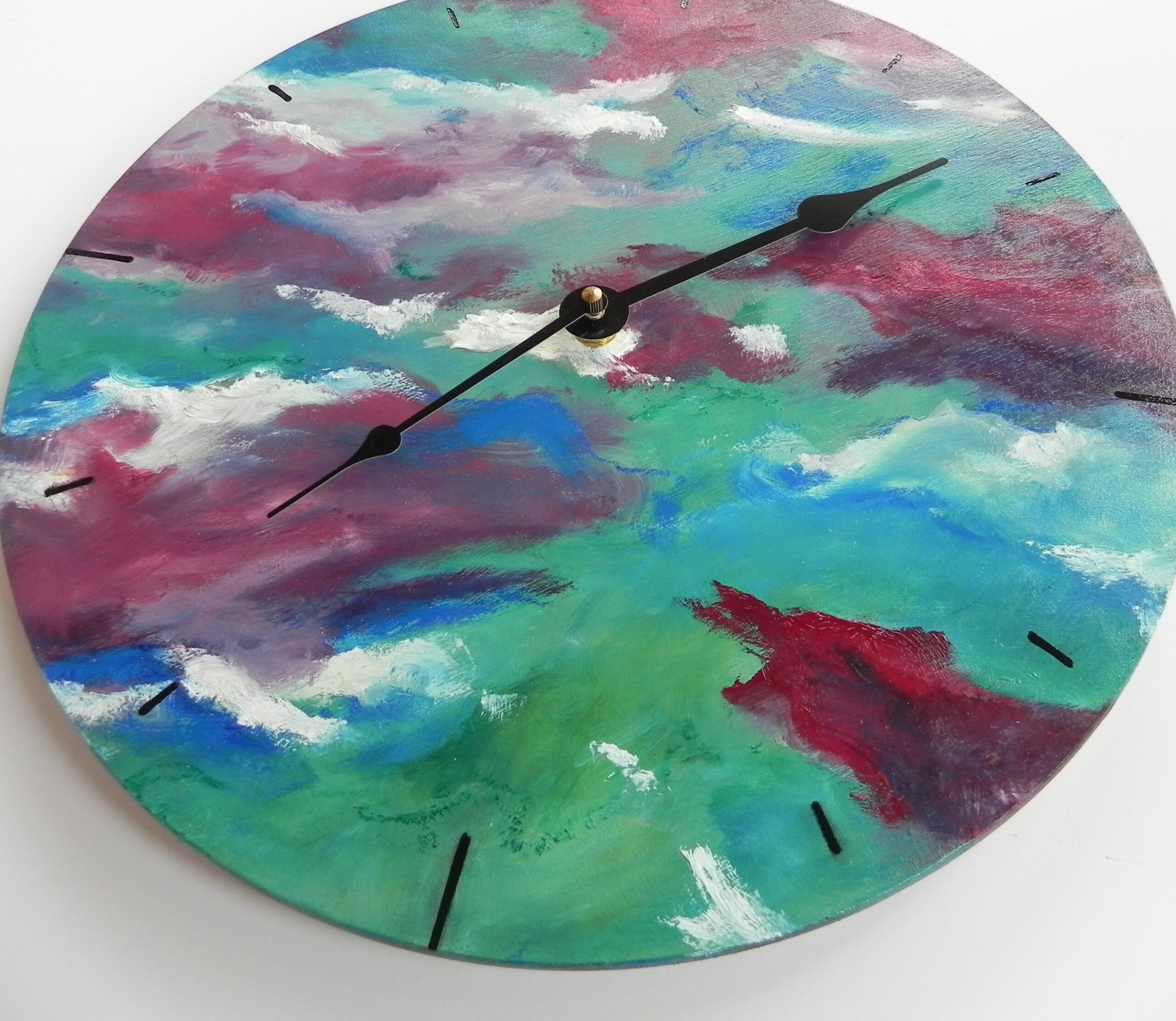Abstract wall clock with teal, pink, and white painted face and black hands