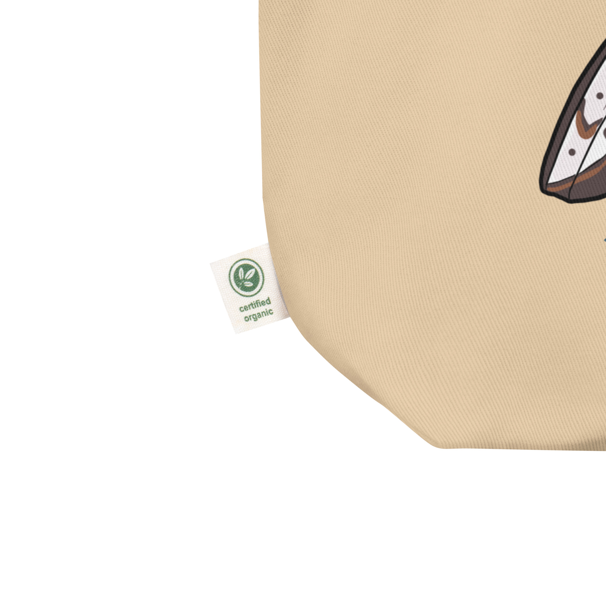 Close-up of beige organic fabric with green certified organic tag and partial graphic print