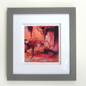 Framed abstract art print with red and orange hues in grey frame