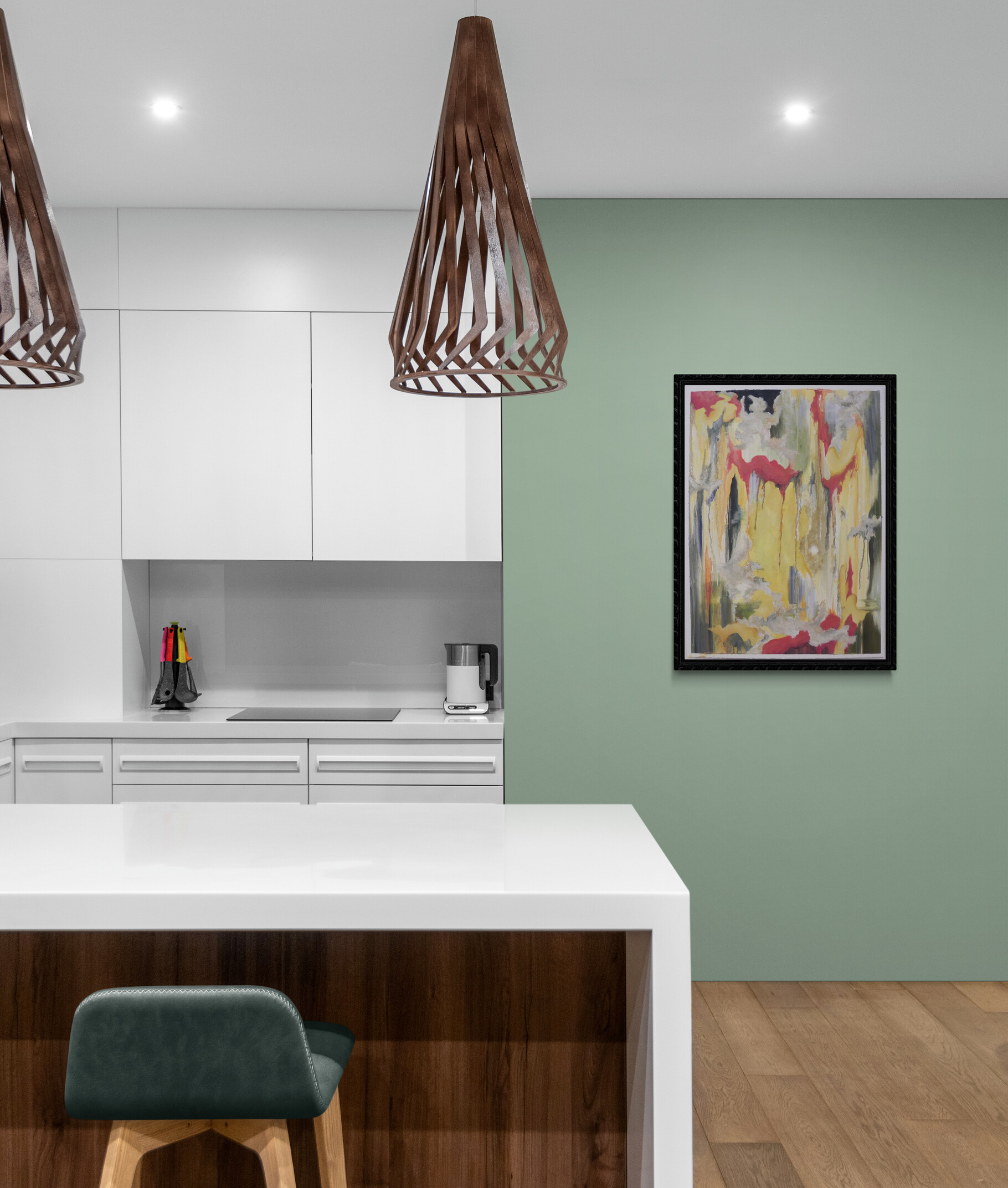 Abstract artwork featuring bold drips of red and yellow in a black frame hanging on a sage green wall above a white kitchen island with pendant lights.