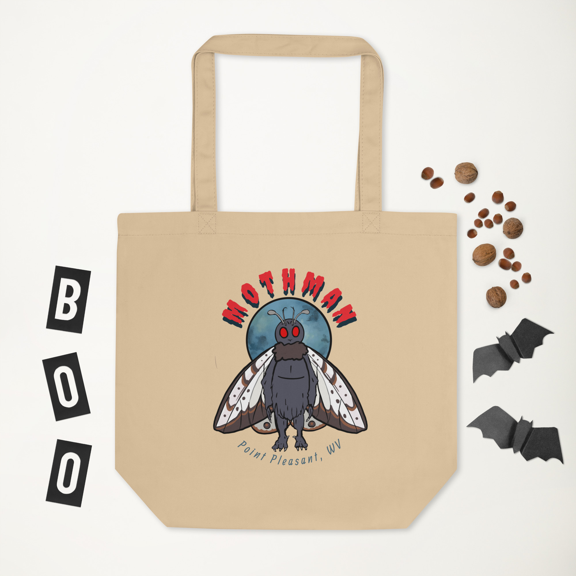 Tan tote bag with Mothman Point Pleasant WV graphic surrounded by Halloween props