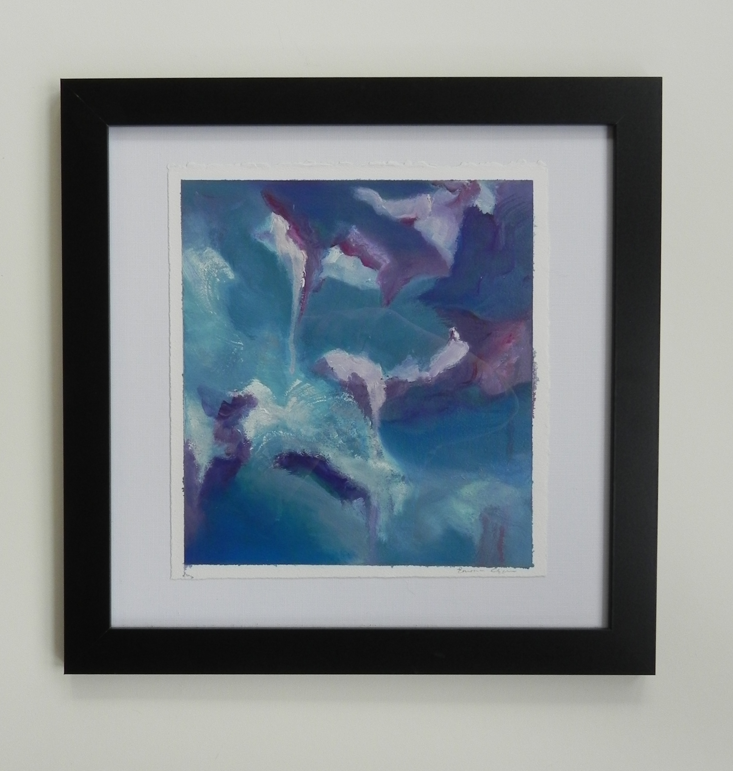 Framed abstract artwork showing deep blue and purple shapes against a teal background, displayed in a black frame with white matting.
