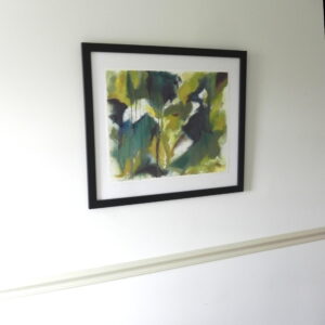 Framed abstract watercolor print with green and yellow hues in black frame