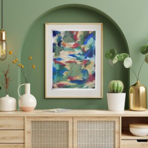 Framed abstract art print with blue, red, and green hues hanging above a wooden console table