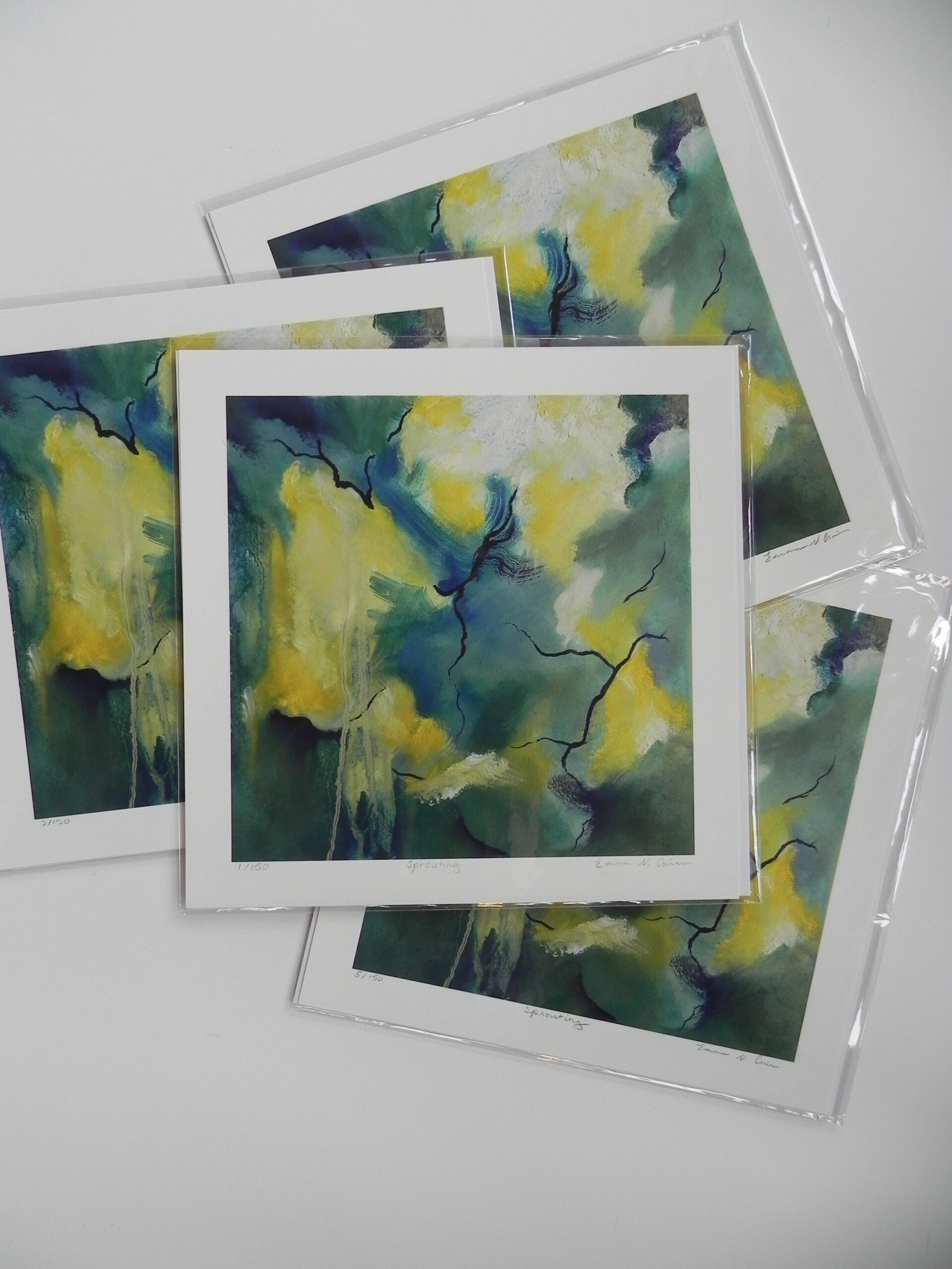Stack of limited edition art prints titled Sprouting featuring abstract green and yellow imagery with black branch-like lines