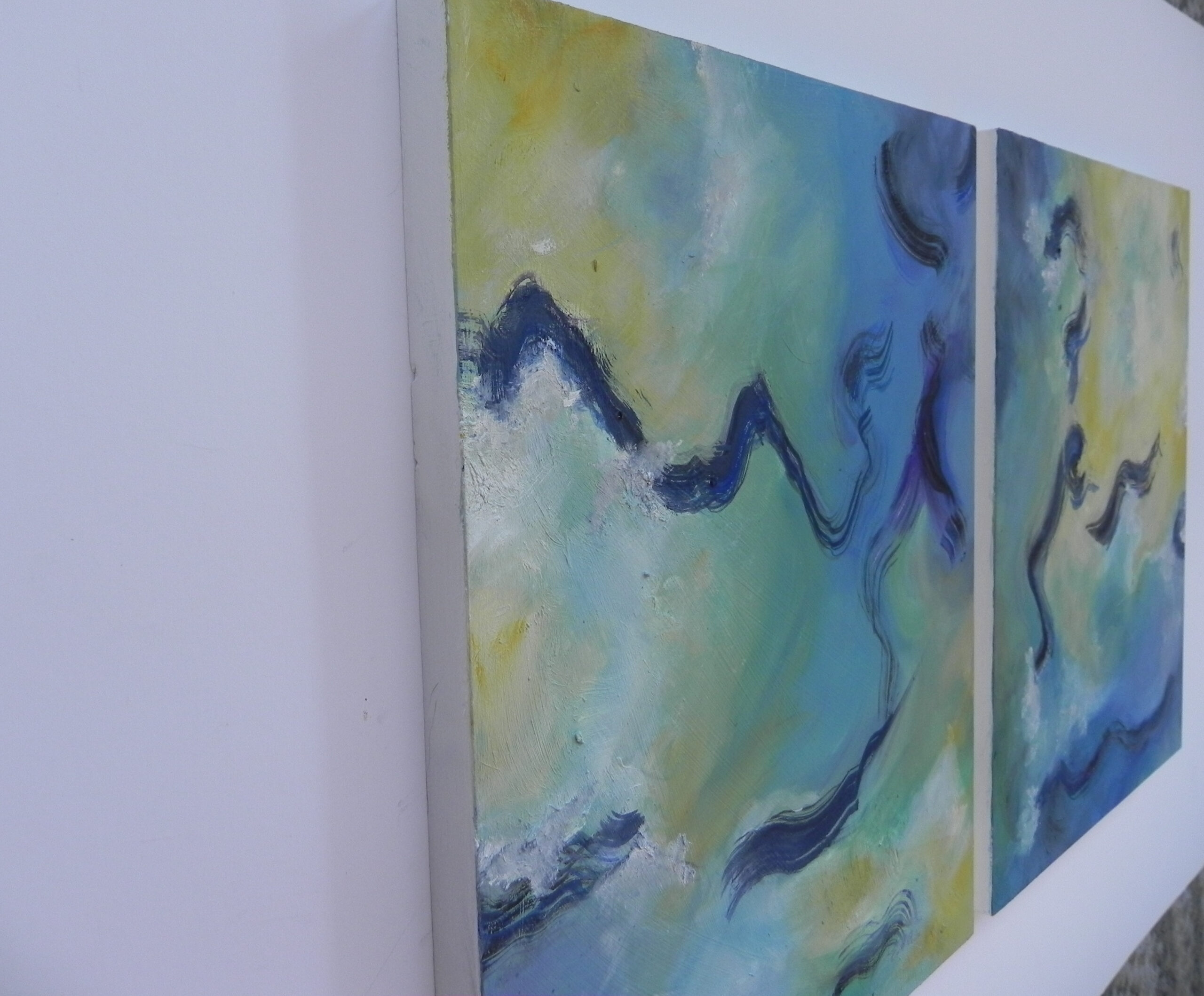 Abstract artwork featuring wavy blue lines across teal and yellow sections, displayed as two horizontal panels in a white frame.