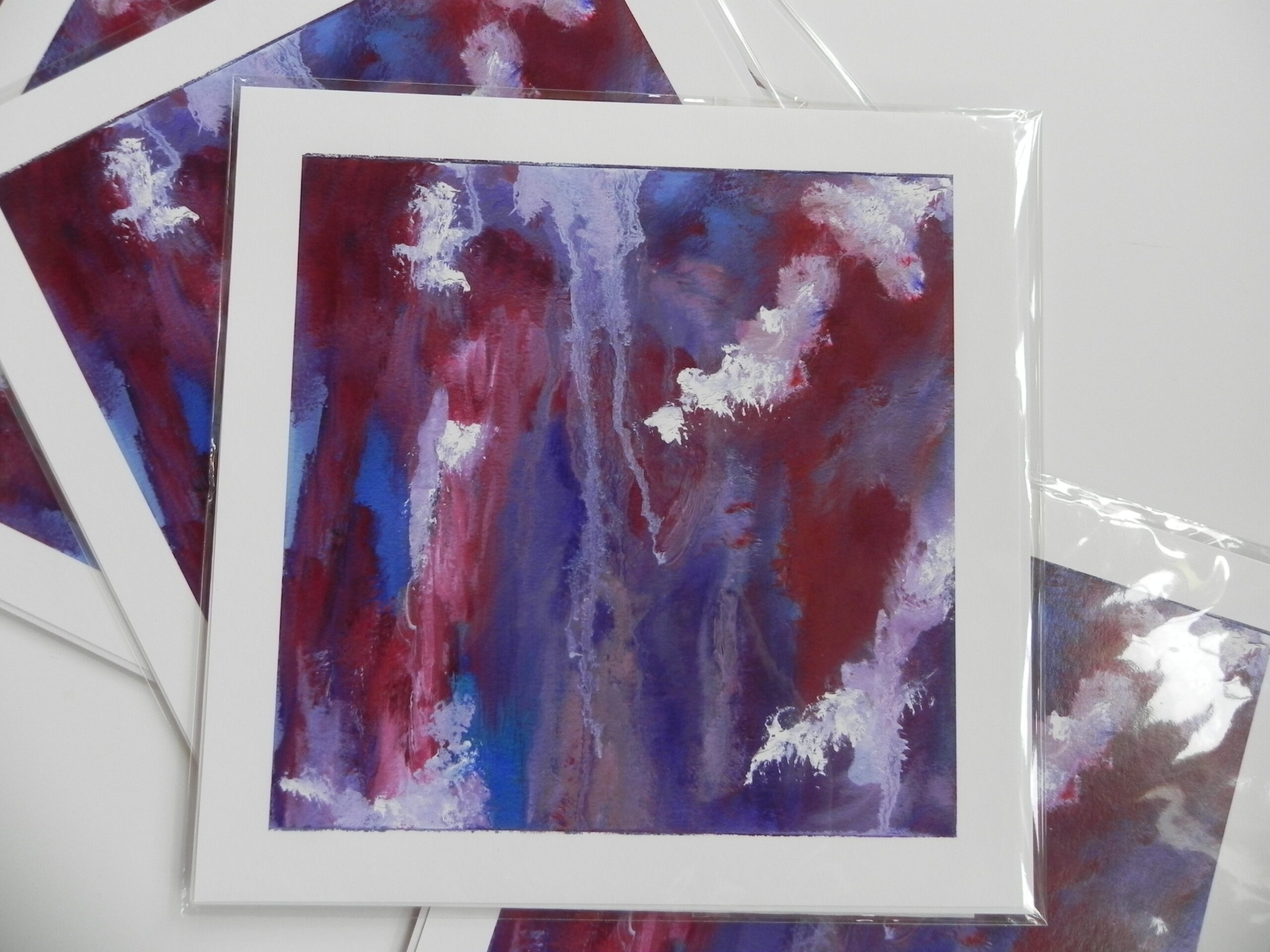 Abstract art print featuring red, blue, and white vertical brushstrokes on white paper in clear plastic sleeve