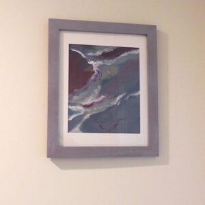 Framed abstract ocean wave artwork in grey frame with white mat hanging on wall