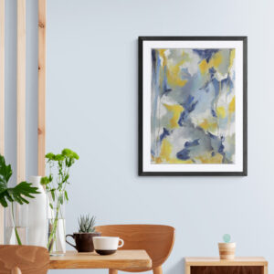 Framed abstract art print with blue, yellow, and white brushstrokes hanging on light blue wall