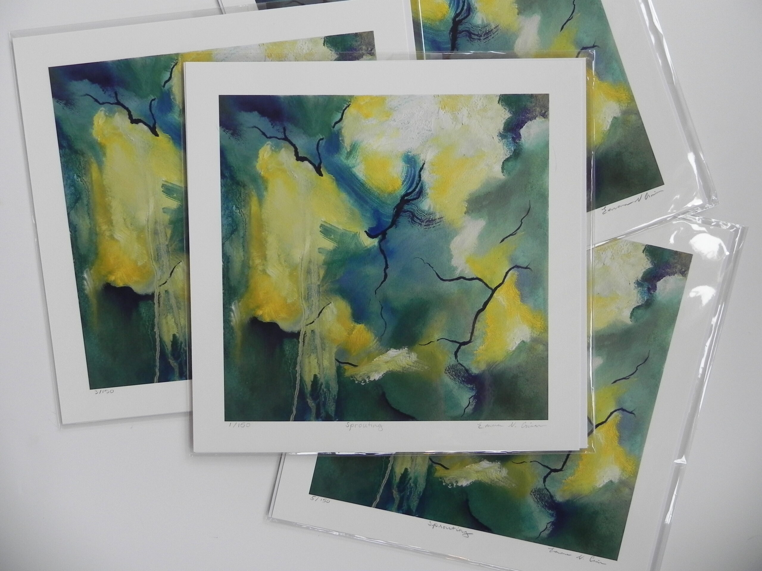 Stack of Sprouting limited edition art prints featuring abstract yellow, green, and blue designs with black branch-like lines.