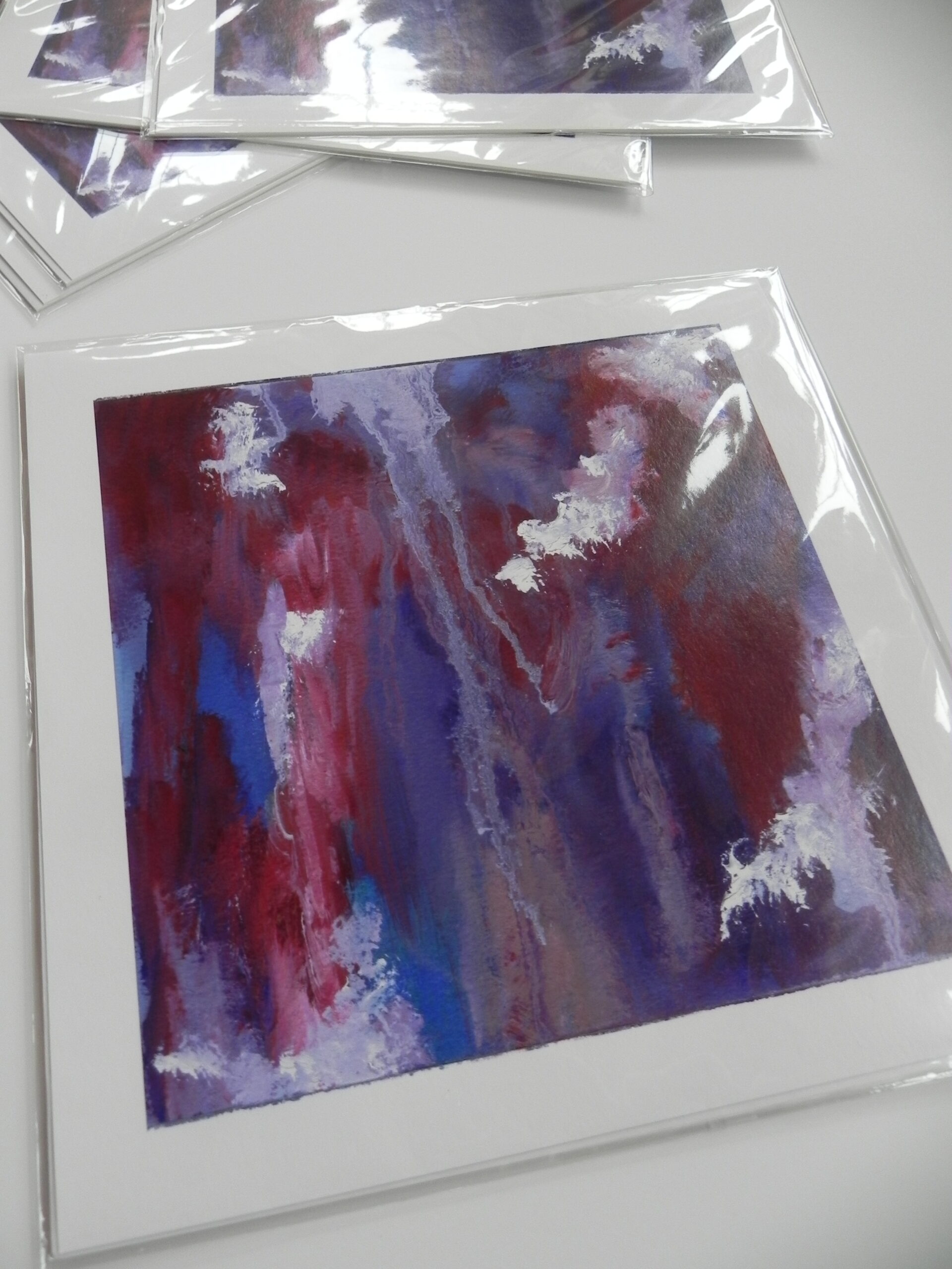 Abstract art print with red, blue, and purple vertical brushstrokes in clear packaging