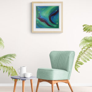 Abstract blue and green painting in a light wood frame hanging above a mint green armchair with houseplants nearby
