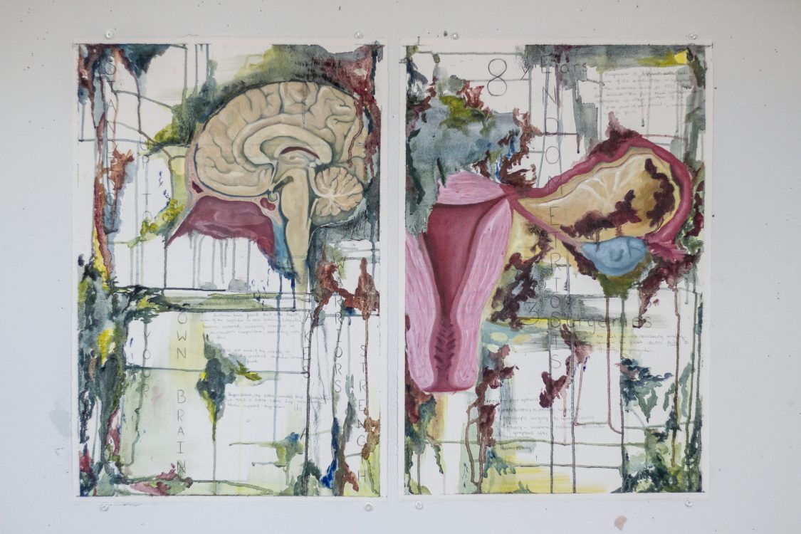 Two watercolor prints showing anatomical illustrations of a brain and uterus with abstract colorful borders and text overlays